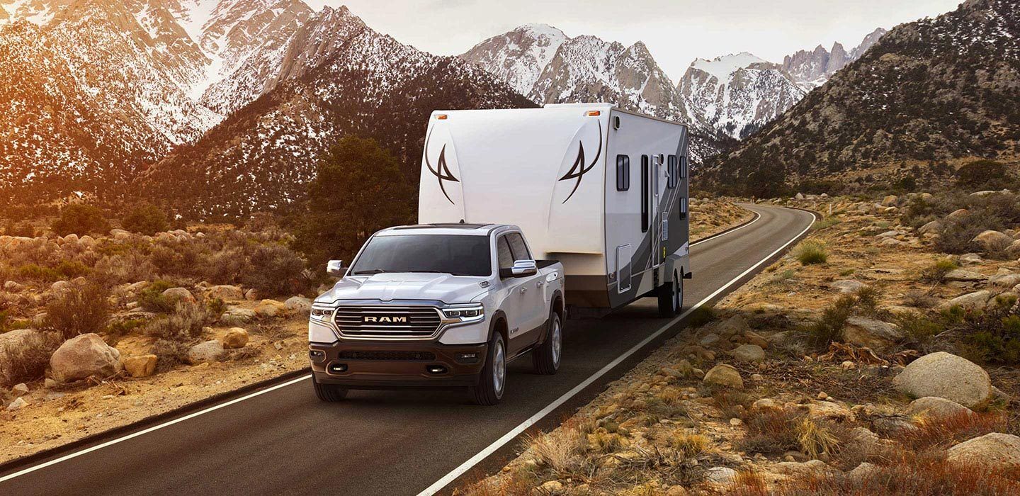 White RAM 1500 Hauling a Camper - Sierra Blanca Motors