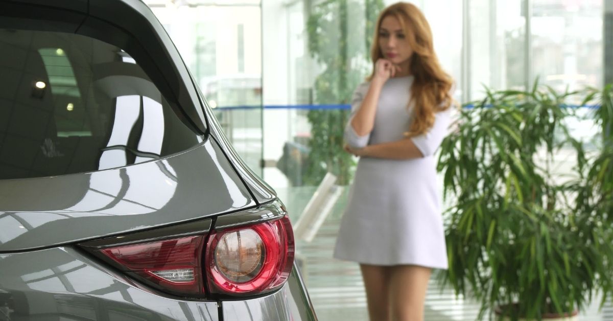 Woman In White Dress At A Dealership Trying To Find The Best Family Car | Sierra Blanca Motors