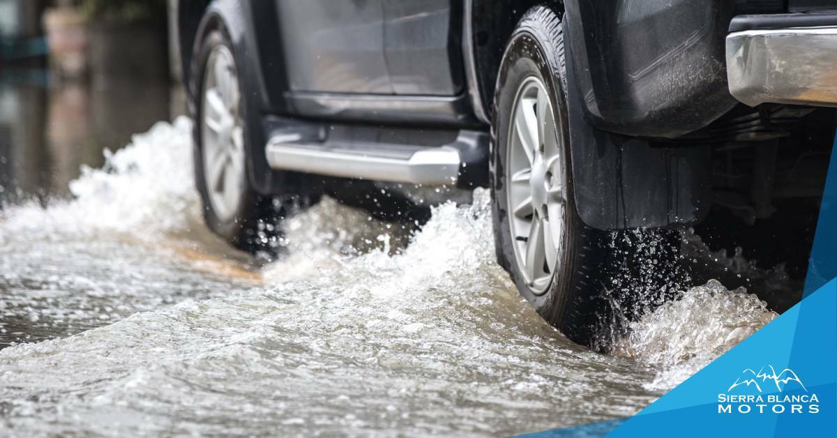 Truck treading through flooded water. Flood damage to vehicle. Sierra Blanca Motors.